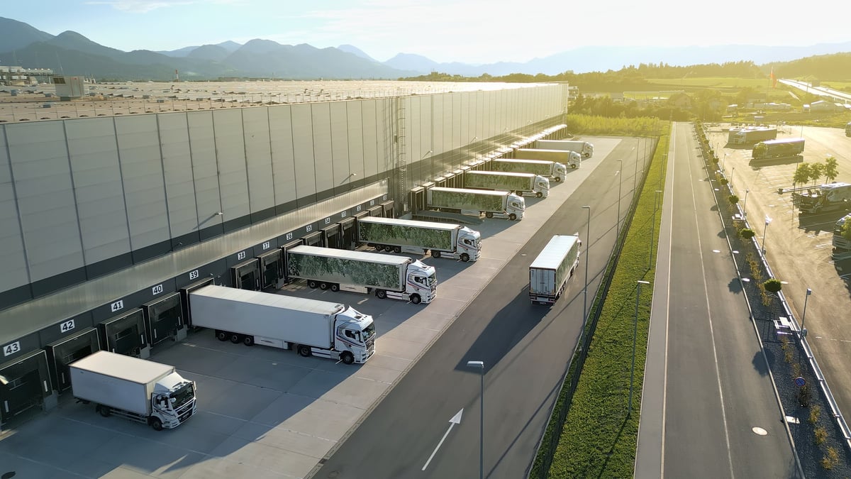 Aerial view of a distribution warehouse with a line of trucks at the loading docks